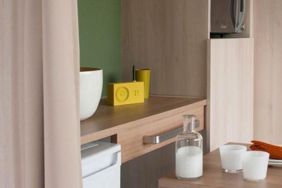 Interno moderno con tavolo, tazze e letto sullo sfondo.