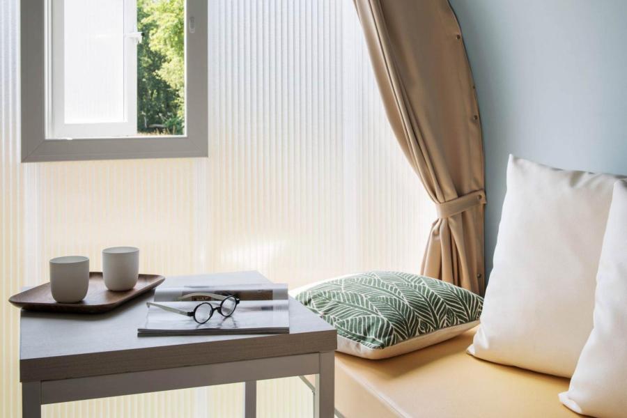 Interno minimalista con divano, tavolino e finestra aperta.